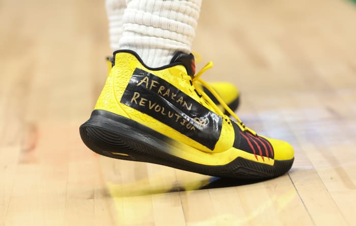 View of Kyrie Irving's yellow and black Nike shoes.